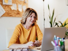 Mature businesswoman working from home and attending video conference meeting